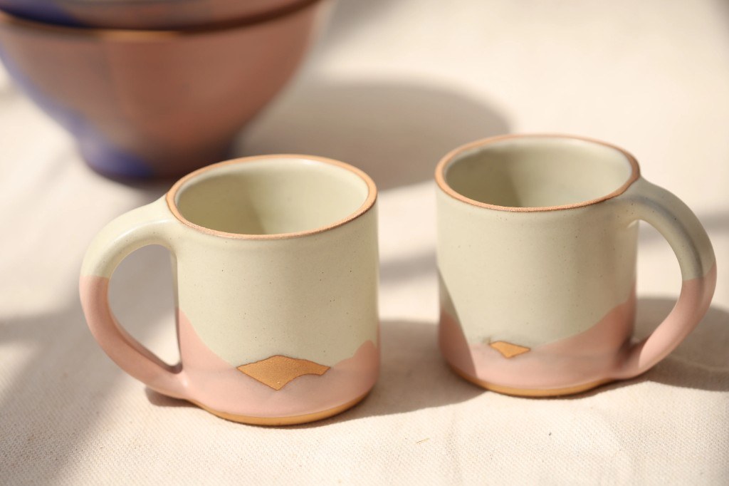 Two cream and pink Sven mugs